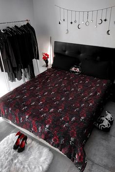 a bed room with a neatly made bed and some shoes on the floor next to it