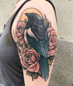 a woman with a tattoo on her arm has a bird and flowers in front of her