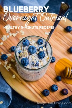 blueberry overnight oatmeal in a glass jar on a wooden cutting board