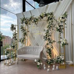 an outdoor wedding ceremony setup with white flowers and greenery on the back drop cloth backdrop