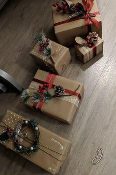 presents wrapped in brown paper with red bows and pine cones on them are sitting on the floor