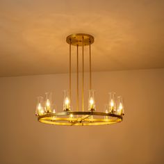 a chandelier hanging from the ceiling in a room with candles lit up on it