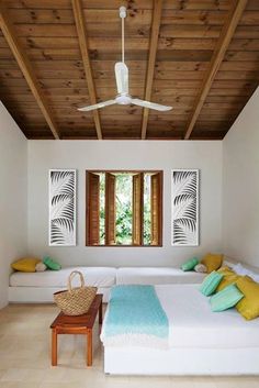 a bedroom with white walls and wooden ceiling