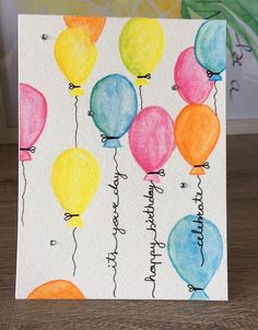 a card with watercolor balloons on it