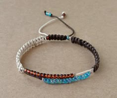 two bracelets with different colored beads and silver findings on a beige tablecloth background