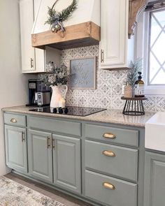 a kitchen with white cabinets and gray counter tops, gold pulls on the handles and knobs