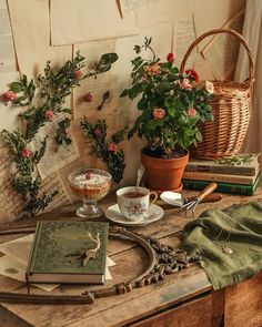 a table topped with books and plants next to a basket filled with flowers on top of it