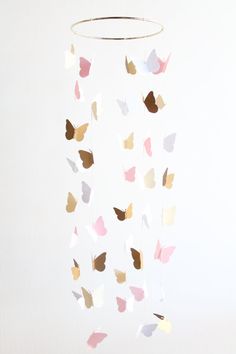 a mobile made out of paper with butterflies hanging from it's sides on a white wall