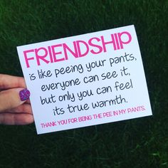 a hand holding a sign that says, friendship is like peeing your pants, everyone can see it, but only you can feel its true warmth