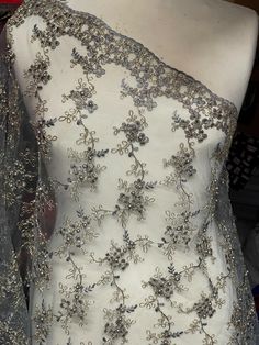 a white dress with silver beading on it