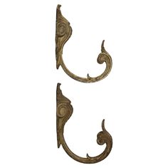 two metal hooks with decorative designs on them