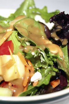 a salad with lettuce, apples and dressing