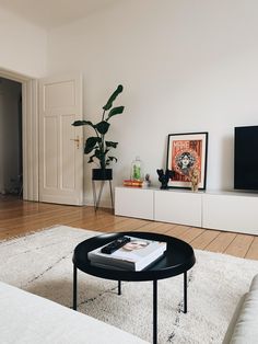 a living room with a couch, coffee table and television on top of the entertainment center