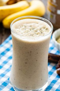 a glass filled with food sitting on top of a blue and white checkered table cloth