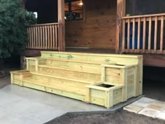 a wooden bench sitting on top of a cement floor next to a porch with stairs