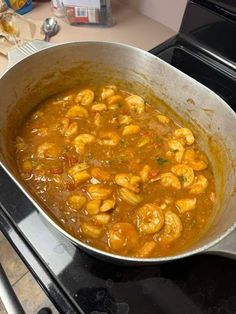 a pan filled with shrimp sitting on top of a stove