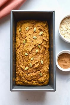 a loaf of pumpkin bread in a pan next to two bowls of oatmeal