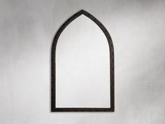 an arched window is shown against a white wall with a black frame on the side