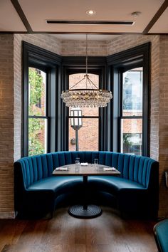 a corner booth with blue upholstered seating and a chandelier