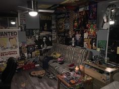 a living room filled with furniture and lots of posters on the wall next to it