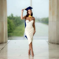 a woman in a graduation gown posing for the camera with her hat on top of her head