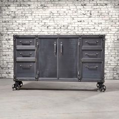 an industrial style metal cabinet with drawers and wheels in front of a white brick wall