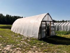 a small greenhouse in the middle of a field