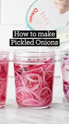 someone is pouring water into three jars filled with red onions