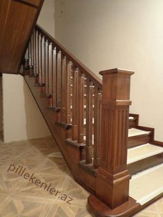 a wooden stair case next to a tiled floor