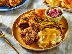 a plate full of fried chicken, mashed potatoes and coleslaw