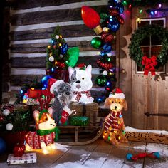 two stuffed animals are sitting in front of a christmas tree with lights and decorations on it