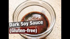 a jar filled with sauce sitting on top of a counter next to a sign that reads dark soy sauce gluten - free