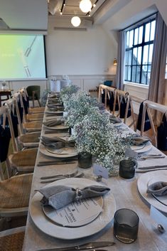 a long table is set with place settings and silverware