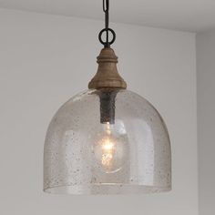 a glass light hanging from a ceiling fixture