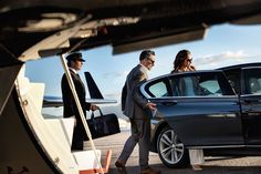 two men and a woman walking towards a car