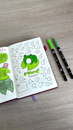 an open notebook with drawings and markers on it