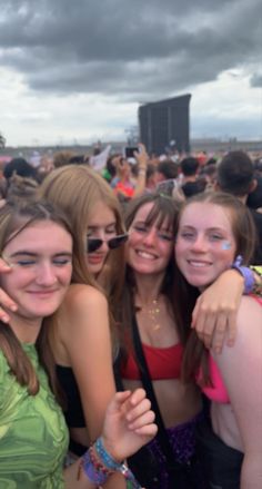 a group of young women standing next to each other at a music festival