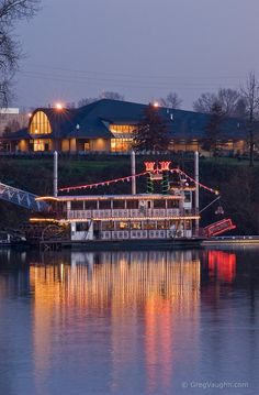 a large boat with christmas lights on it's side in the water