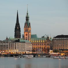 a large building that has a clock tower on it's side next to the water