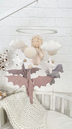 a baby crib with a stuffed animal hanging from it's side, next to a white brick wall