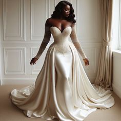 a woman in a wedding dress standing next to a window with her hands on her hips