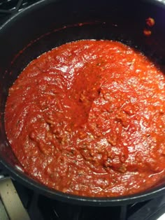 a pan filled with sauce sitting on top of a stove