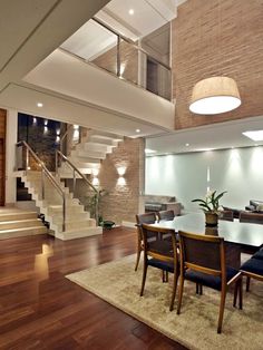 a dining room and living room with stairs leading up to the second floor in this modern home