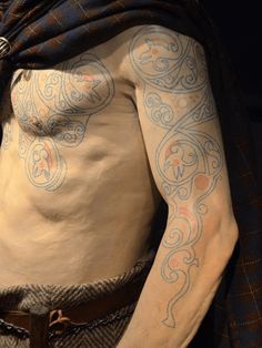 a man with tattoos on his arms and chest