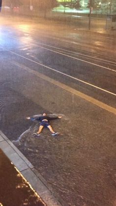 a man standing in the middle of a flooded street