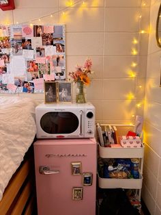 a pink refrigerator freezer sitting next to a bed