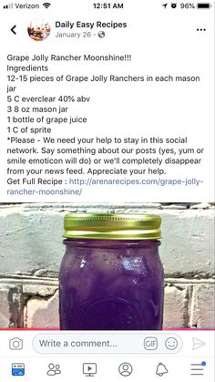 a purple jar filled with liquid sitting on top of a wooden table next to a brick wall