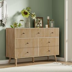 a wooden dresser sitting next to a green wall