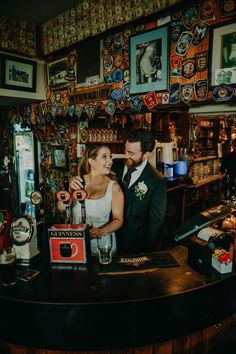 a bride and groom standing at the bar