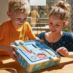 two young children playing with an open box